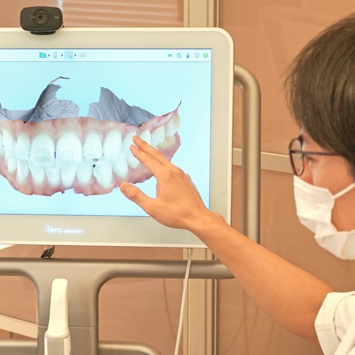 治療計画を画面で説明する院長